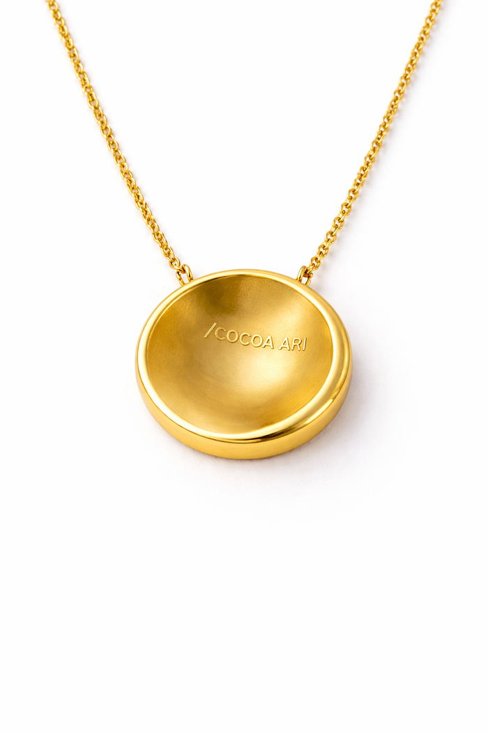 COCOA ARI gold demi-fine pendant necklace with engraved branding, small-batch jewelry design