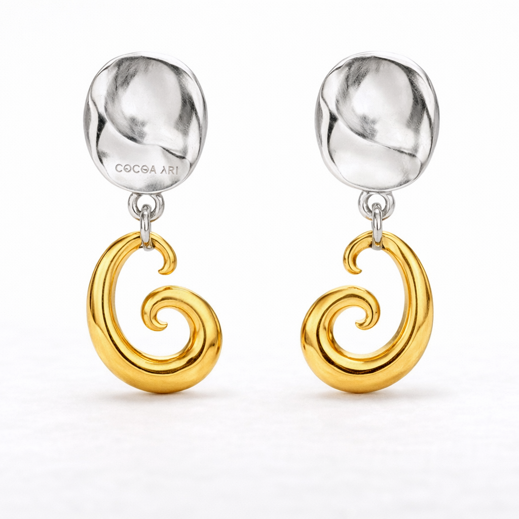 COCOA ARI two-tone earrings with sculpted silver studs and gold swirl pendants on white background