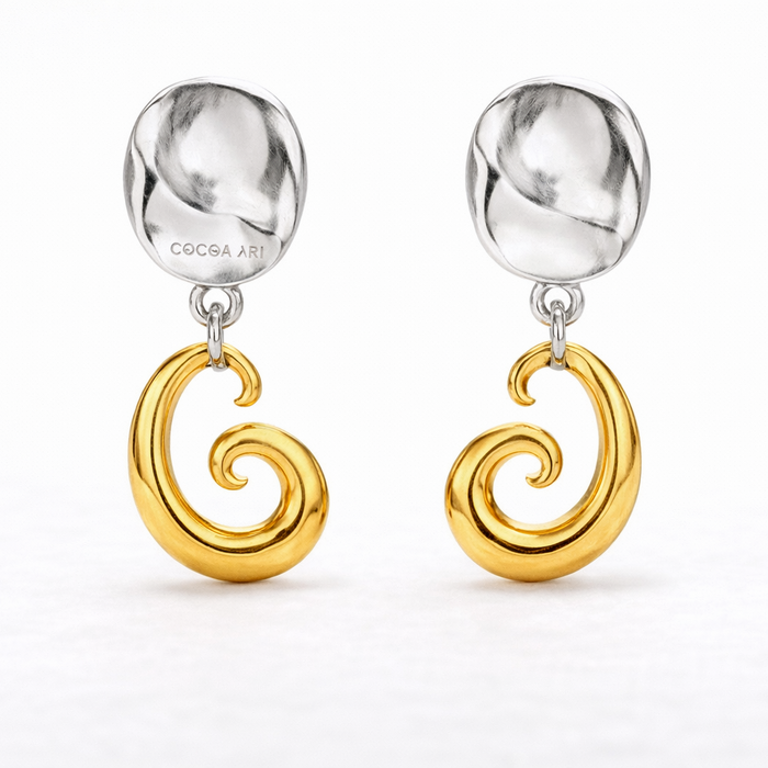 COCOA ARI two-tone earrings with sculpted silver studs and gold swirl pendants on white background