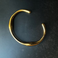 Gold bracelet on a dark gray background