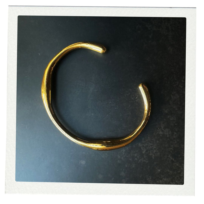 Gold bracelet on a dark gray background