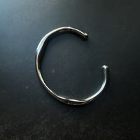 Silver bracelet on a dark surface