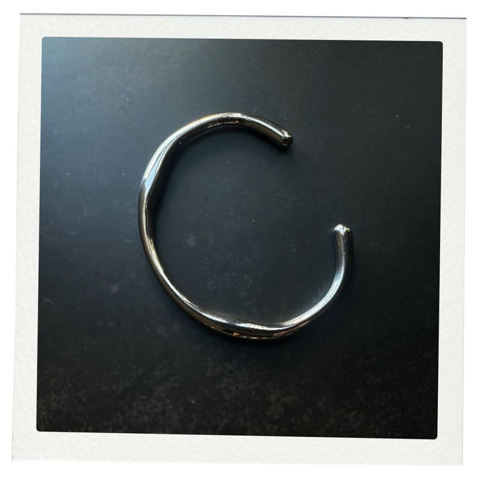 Silver bracelet on a dark surface