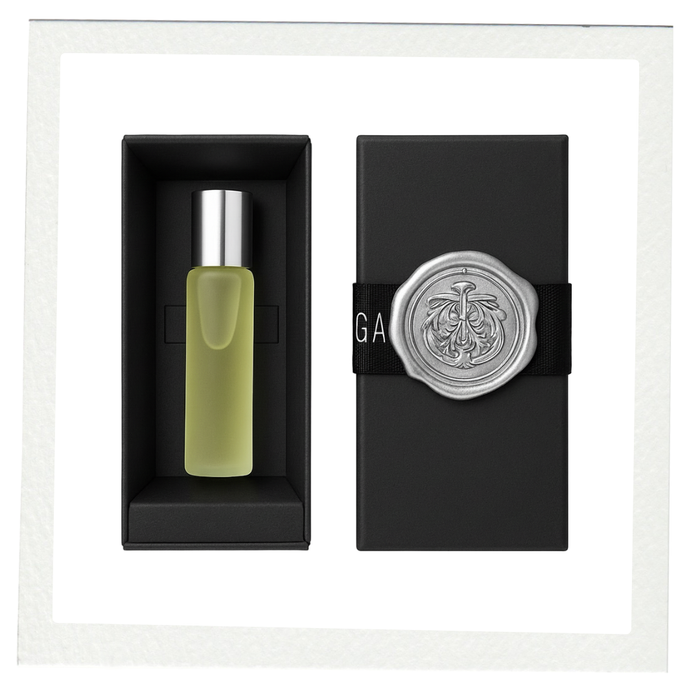 COCOA ARI No. 1 perfume oil in a frosted glass bottle with silver cap, beside a black gift box sealed with an embossed silver medallion.