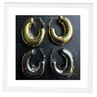 COCOA ARI Avenue Duo gold and silver chunky hoop earrings on black background