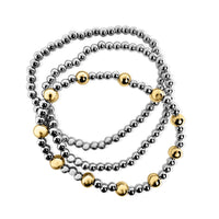 Set of three beaded bracelets in silver, gold, and bronze on a white background