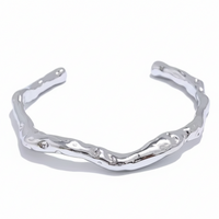 Silver bracelet with wavy design on a white background