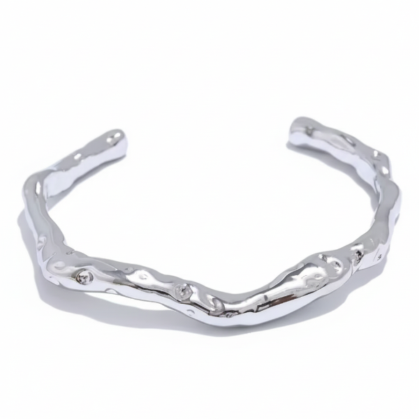 Silver bracelet with wavy design on a white background
