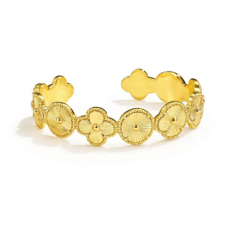 Gold bracelet with floral and circular designs on a white background