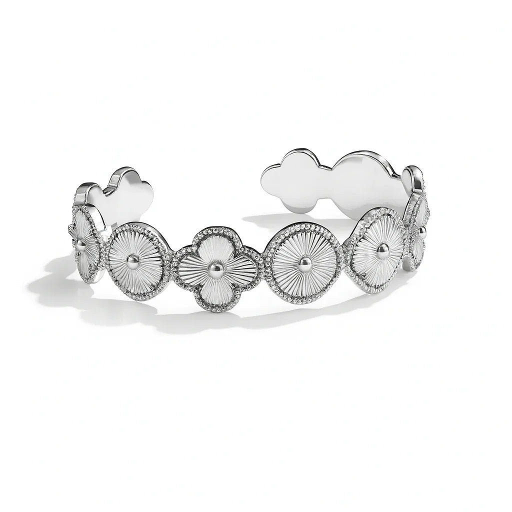 Silver bracelet with floral and heart designs on a white background