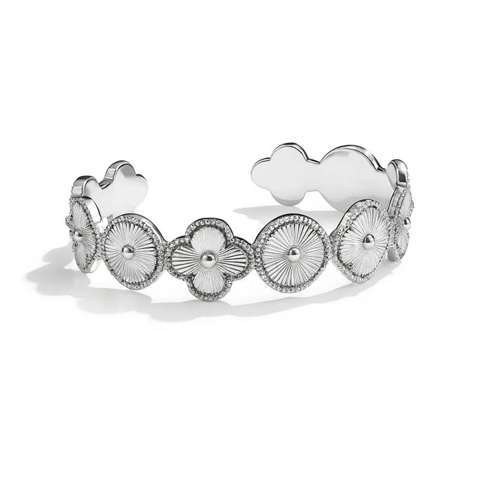 Silver bracelet with floral and heart designs on a white background