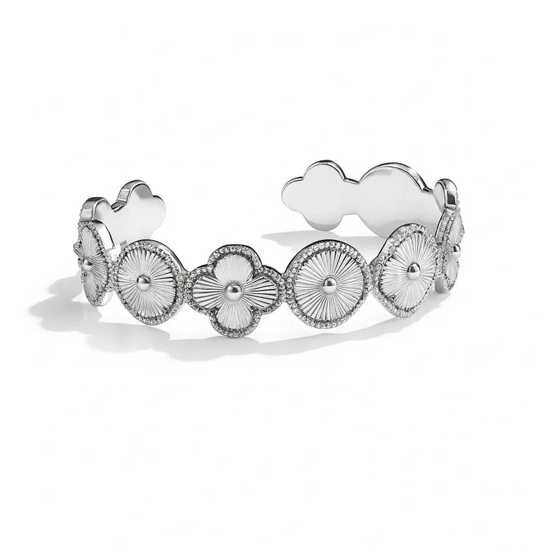 Silver bracelet with floral and heart designs on a white background