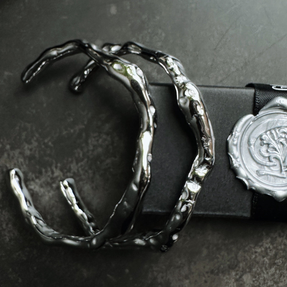 Silver cuff bracelet on a dark surface