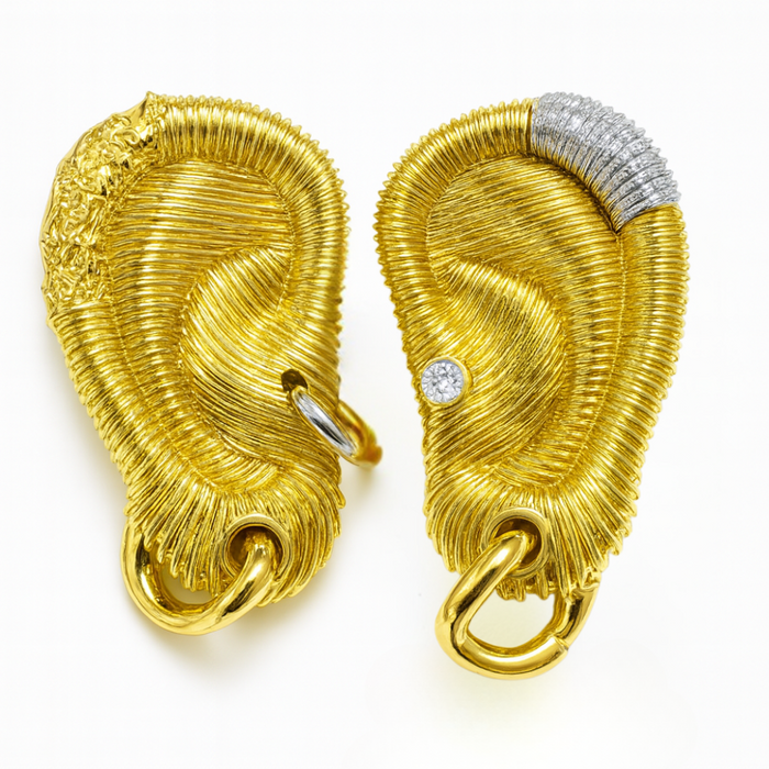 Gold ear earrings with intricate designs on a white background