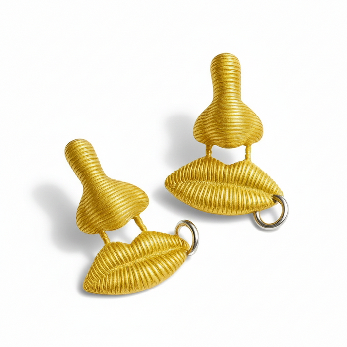 gold earrings with lips and nose on white background