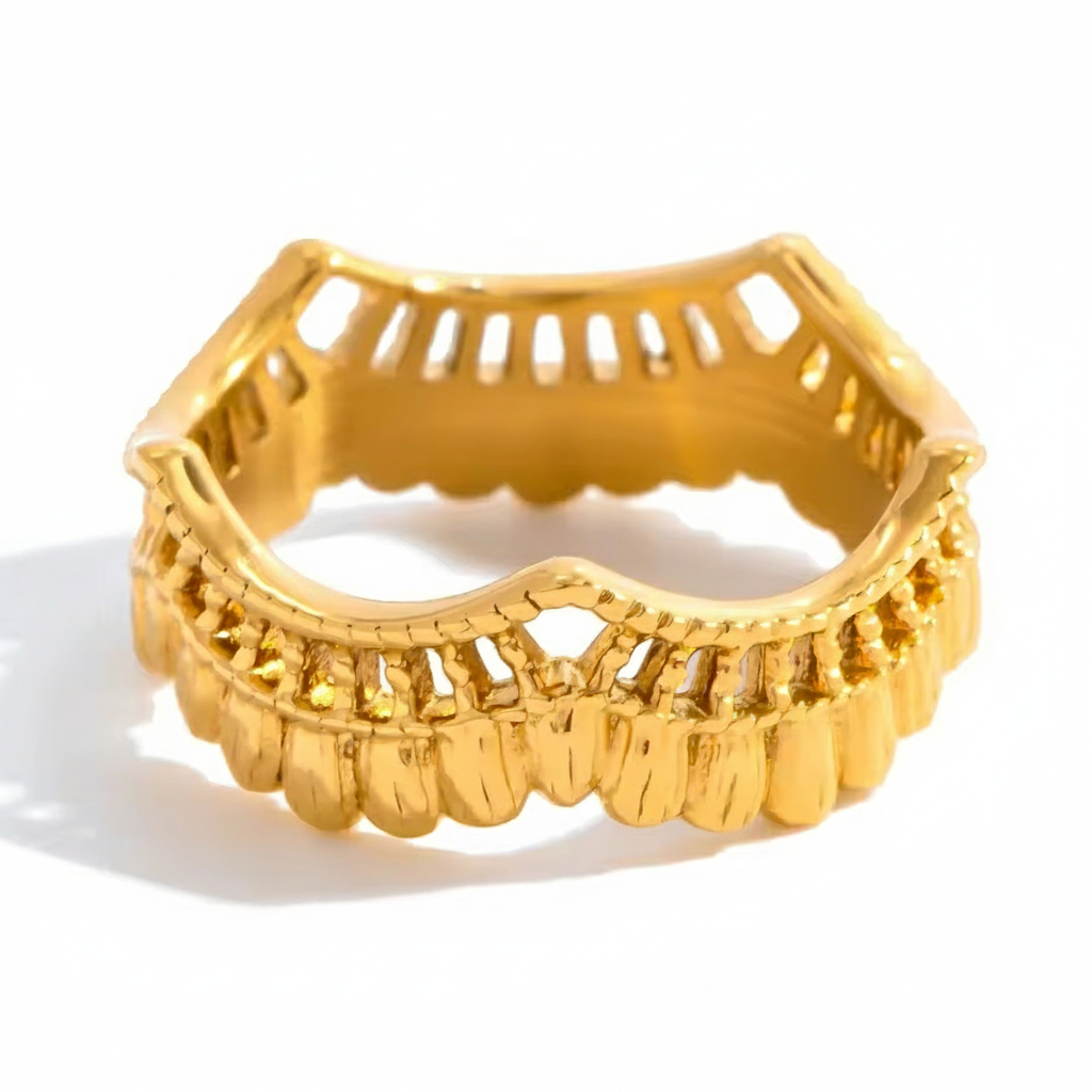 Gold ring with intricate design on a white background