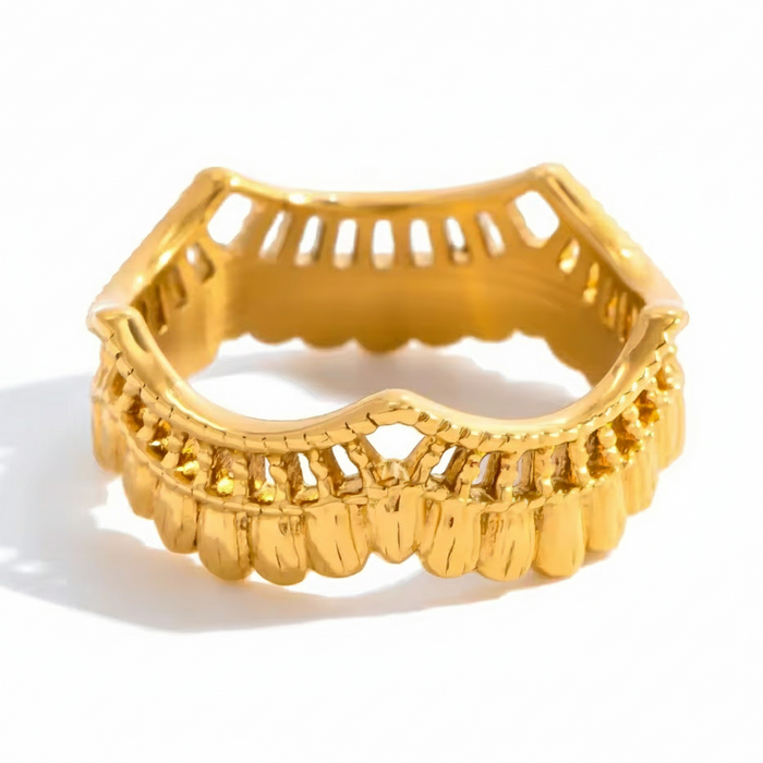 Gold ring with intricate design on a white background