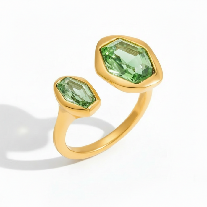 Gold ring with green gemstones on a white background