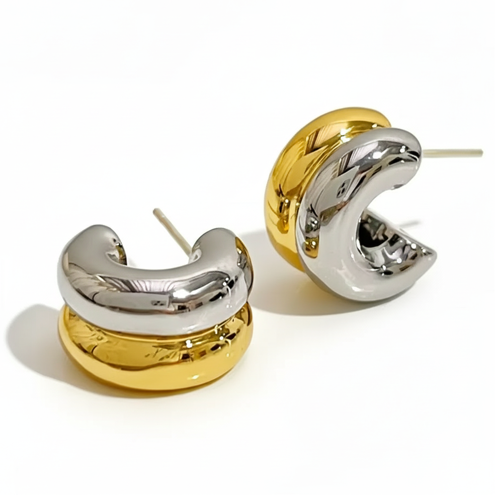 Pair of gold and silver hoop earrings on a white background