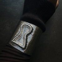 Ribbed textured silver bracelet cuff with keyhole design on wrist