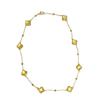 Gold station necklace with yellow crystal clover motif stones white background