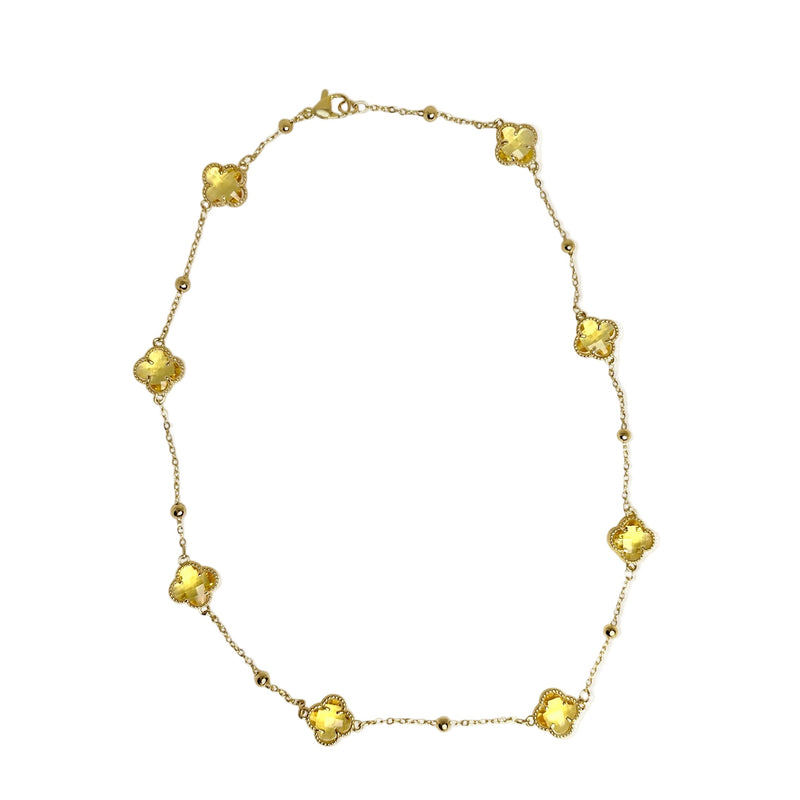 Gold station necklace with yellow crystal clover motif stones white background