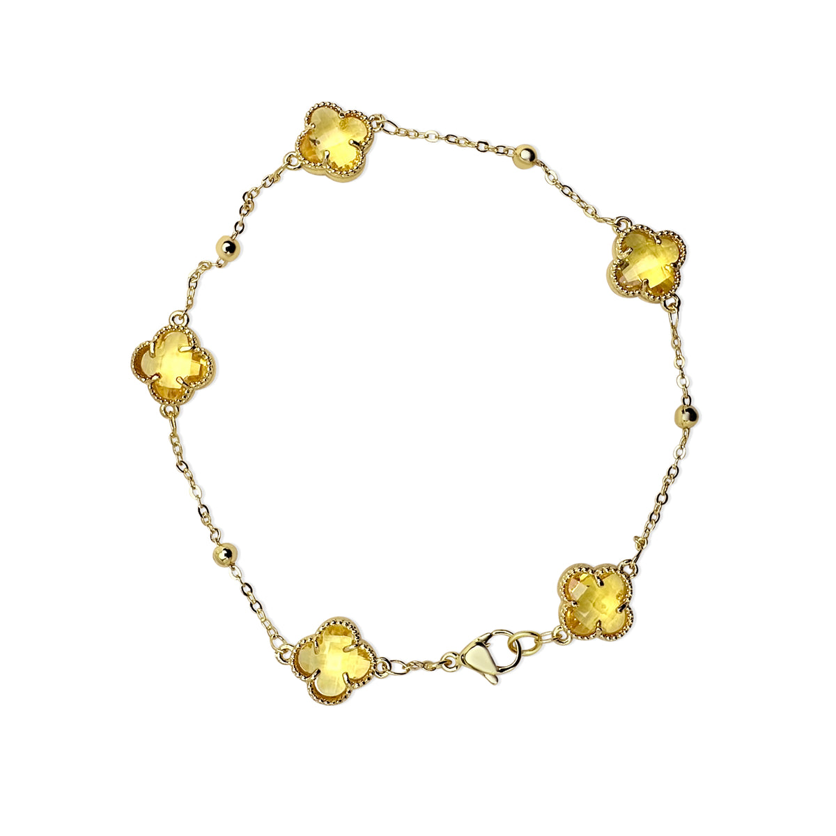 Gold bracelet with yellow gemstones on a white background